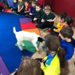 kids petting a goat in class